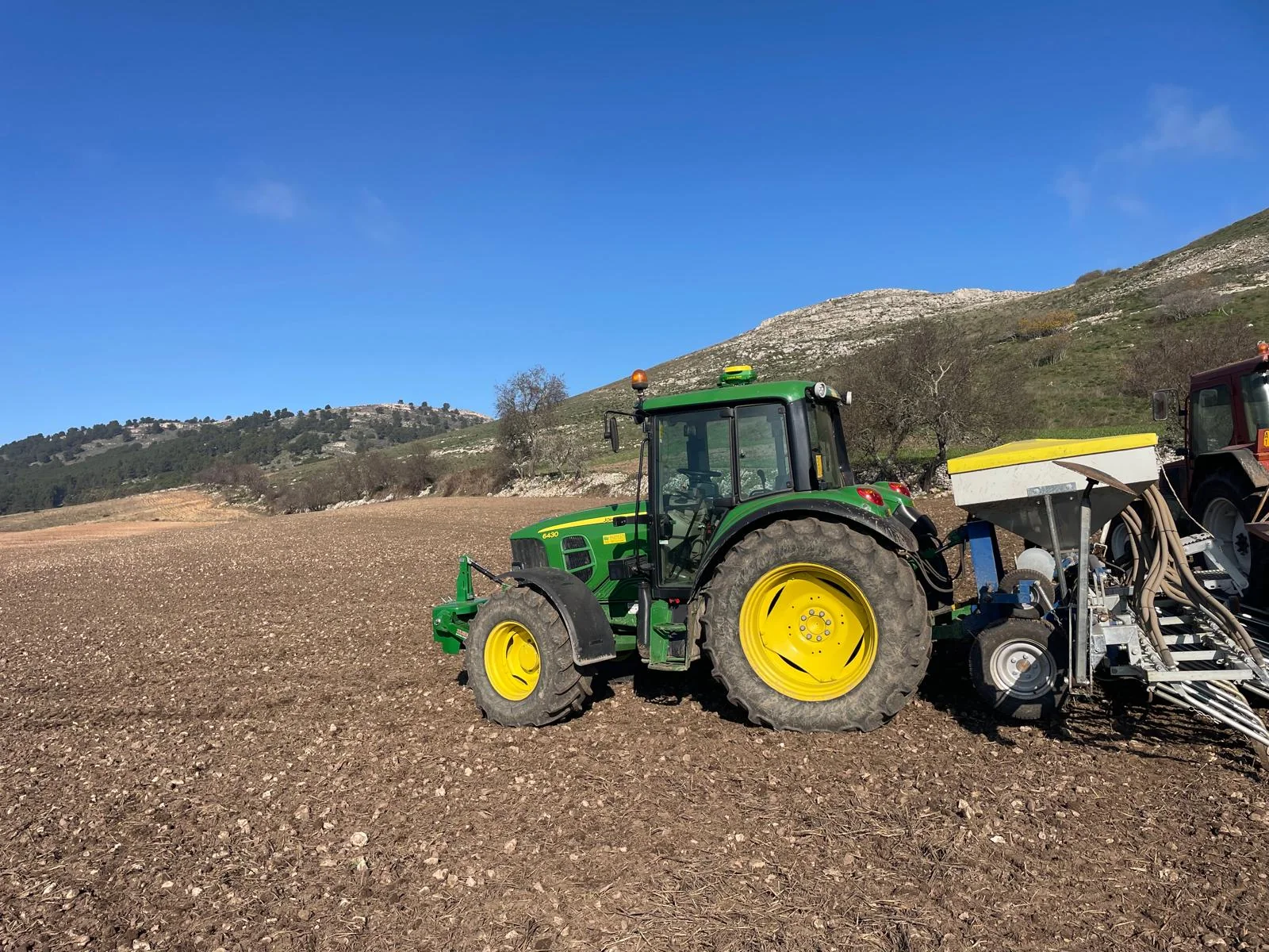 Trattore John Deere con seminatrice al lavoro